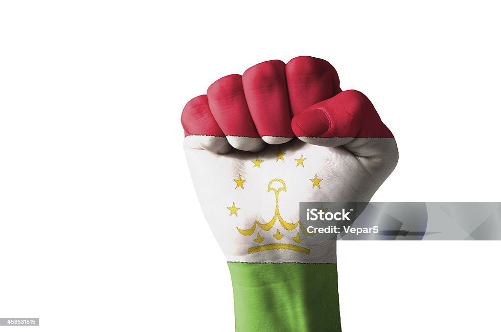 Fist painted in colors of tajikistan flag Low key picture of a fist painted in colors of tajikistan flag Aggression Stock Photo