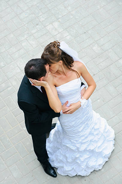istock happy wedding couple standing, kissing and embracing 453535663