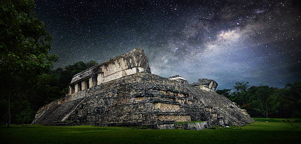 Galactic night starry sky over  ancient Mayan city of Palenque. stock photo