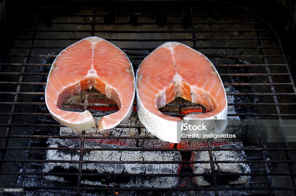 Two fresh salmon steaks on BBQ Two fresh salmon steaks on BBQ. Whole background. Cooking Stock Photo