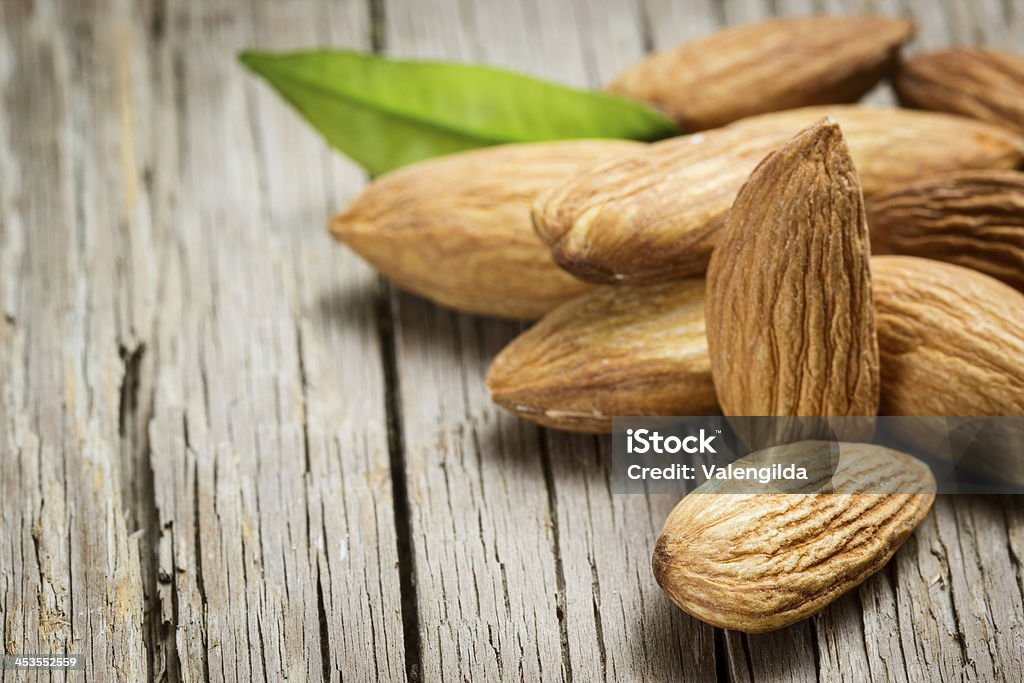 Almonds with leaf Almonds with leaf on wooden background Almond Stock Photo