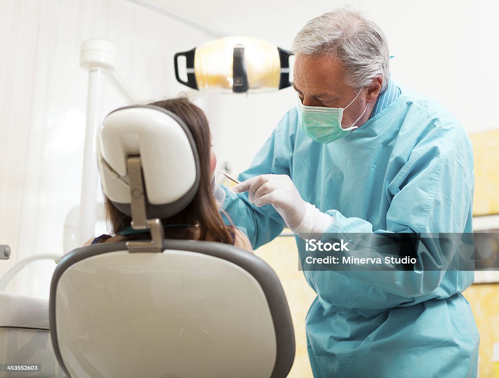 Dentista facendo un trattamento - Foto stock royalty-free di Adulto