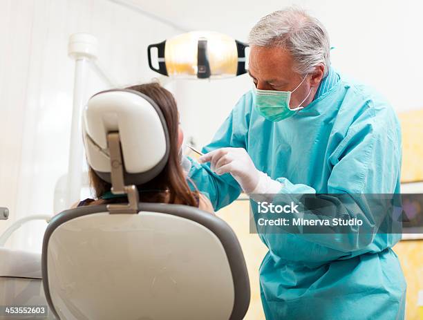 Dentista Facendo Un Trattamento - Fotografie stock e altre immagini di Adulto - Adulto, Ambulatorio dentistico, Attrezzatura
