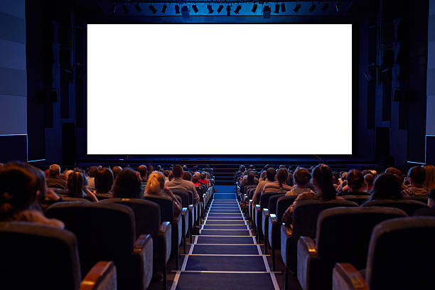 Empty cinema screen with audience. Empty cinema screen with audience. Ready for adding your picture. Screen has crisp borders. This shot was made using tripod with long exposure. Watching stock pictures, royalty-free photos & images