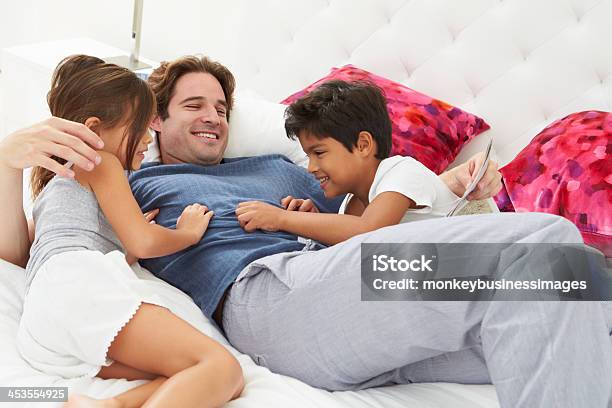 Foto de Pai E Filhos Relaxante Na Cama Juntos e mais fotos de stock de 20 Anos - 20 Anos, 4-5 Anos, 8-9 Anos