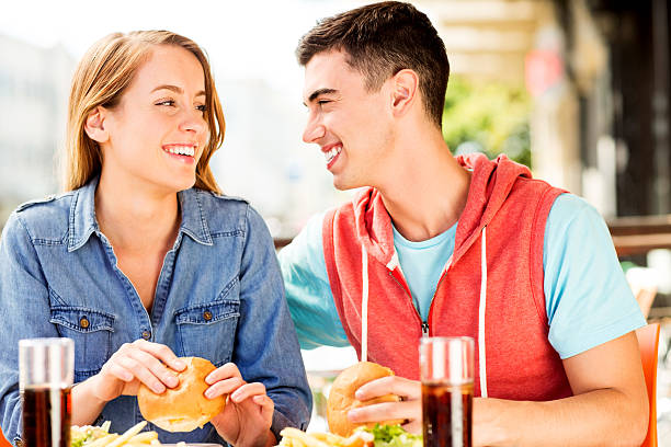 istock Couple Looking At Each Other While Eating Fast Food 453555953