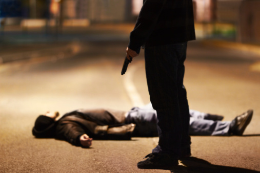 Man lying on the ground after being shot by a gun-wielding criminal