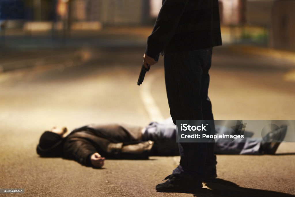 Acts of violence Man lying on the ground after being shot by a gun-wielding criminal Murder Stock Photo