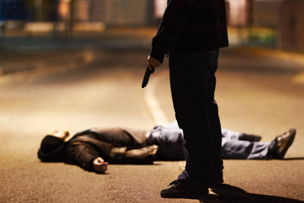 Acts of violence Man lying on the ground after being shot by a gun-wielding criminal assassination photos stock pictures, royalty-free photos & images