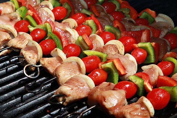 delicioso! uma colorida fileira de shish kebabs - barbecue grill broiling barbecue vegetable - fotografias e filmes do acervo