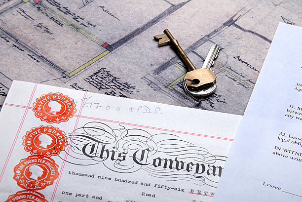 istock Property Mortgage deeds and house keys sit on top plans 453572441