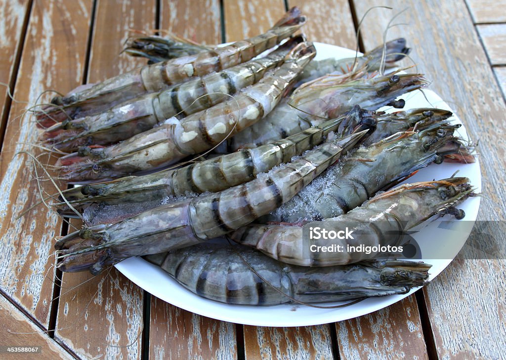 Fresh Shrimp in a plate on the garden table. Fresh Shrimp in a white plate on a garden table. Close-up Stock Photo