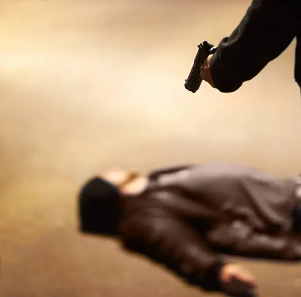 Man lying on the ground after being shot by a gun-wielding criminal