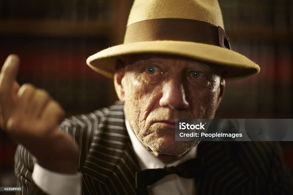 Are you talking to me? Closeup of an aged mob boss wearing a hat and looking serious Gangster Stock Photo