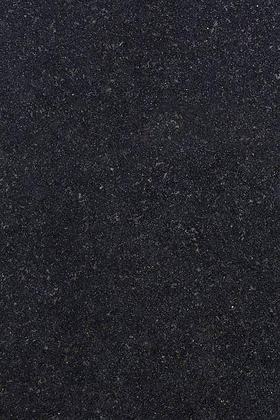 Absolute Black Granite a high definition view of Absolute Black  Granite (also known as Absolutto Black or Indian Black Granite) with its fine dense jet-black and silvery grains creating a very dark finish that is known to be very hard and durable. Originating from Southern India, this type of granite is used extensively for decorative purposes in kitchens, bathrooms, work tops, monuments, facades and also flooring. schist stock pictures, royalty-free photos & images