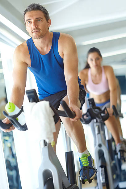 A man and woman exercising in exercising class at the gym