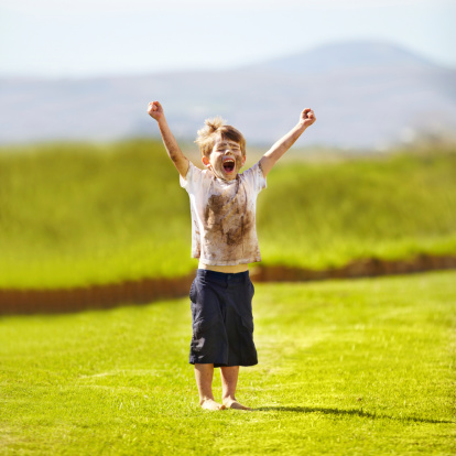 Cute little boy cheering while standing outdoors