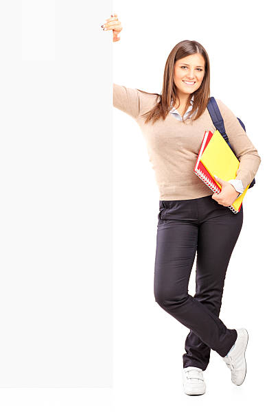 istock Smiling female student standing next to a billboard 453596431