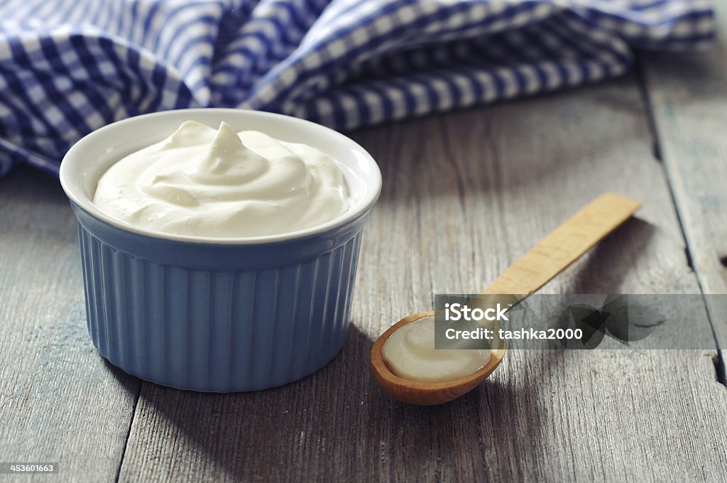 Greek yogurt Greek yogurt in a ceramic bowl with spoons on wooden background Sour Cream Stock Photo