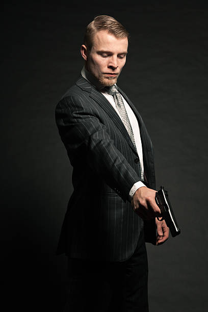 istock Man in suit shooting with gun. 453602051