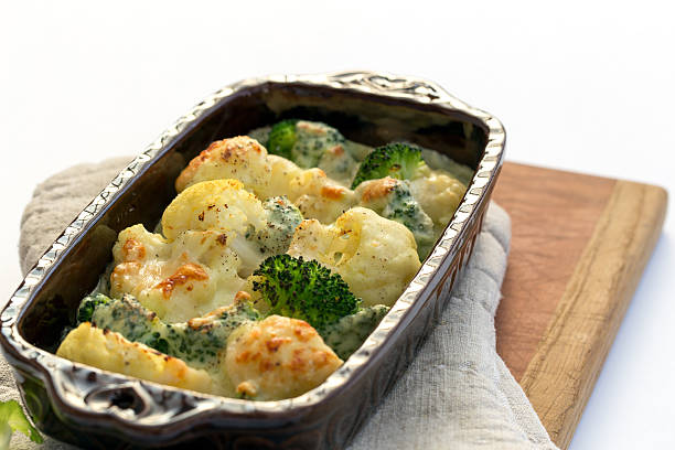 casserole with broccoli, chicken and cheese on plate, lighted candles on the table