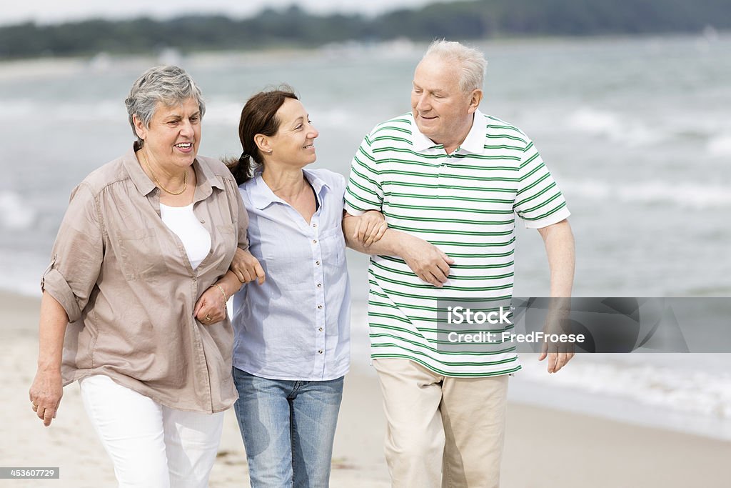 Senior coppia e assistente in spiaggia - Foto stock royalty-free di Assistente domiciliare