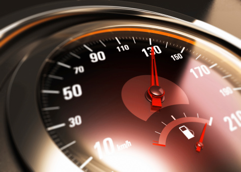 Close up of a car speedometer with the needle pointing 130 Km h, blur effect, conceptual image for speed limit.