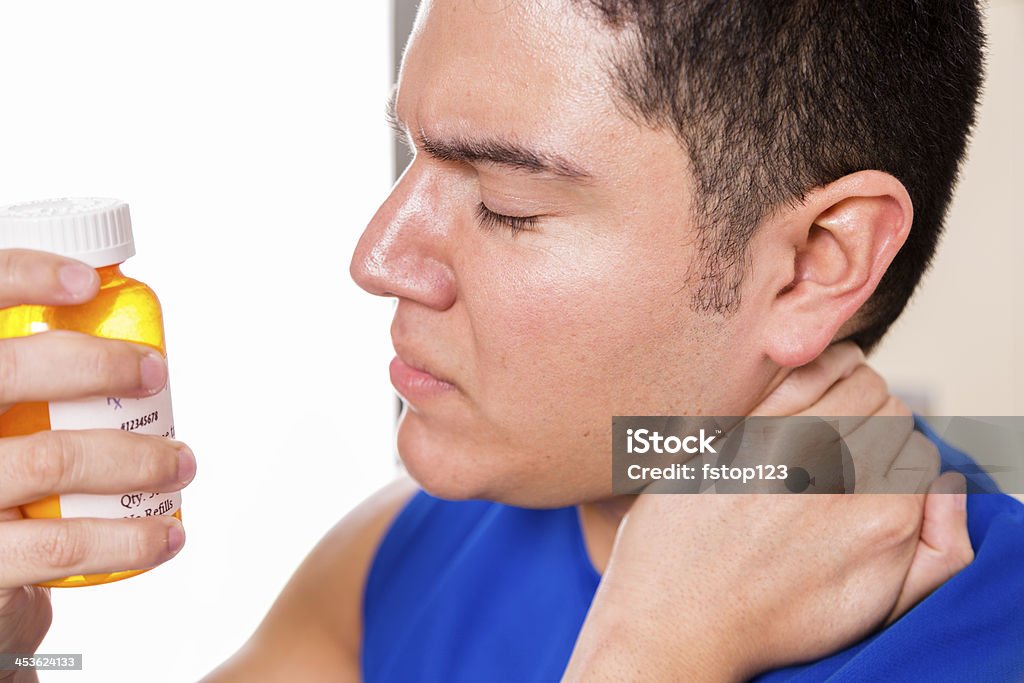 Medicina: Atleta maschio Massaggiare collo dolore, che tiene la bottiglia di medicina. - Foto stock royalty-free di 20-24 anni