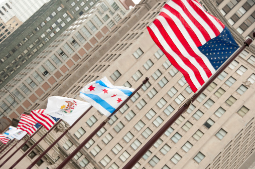 Flags along the Michigan Avenue bridge in Chicago with office and apartment buildings in the background.