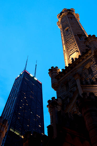 John Hancock Tower and Chicago Water The John Hancock Tower and Chicago Water Tower on Michigan Avenue Illuminated at Twilight. water tower chicago landmark stock pictures, royalty-free photos & images