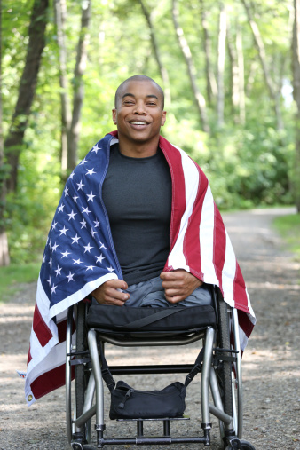 young amputee in wheelchair with american flag
