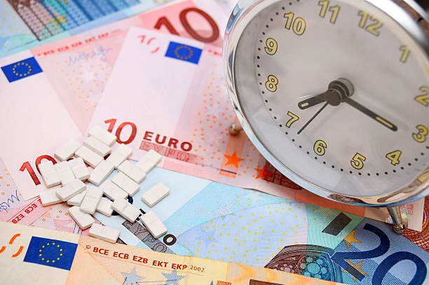 istock Alarm clock and tablets for euro banknotes. 453637509