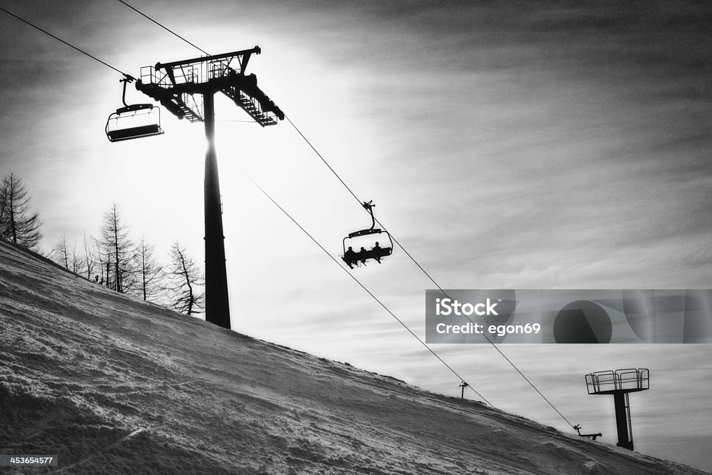 Chair Lift Three skiers riding a chairlift.Krvavec,Slovenija;Europe Black And White Stock Photo
