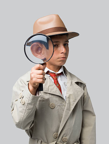 istock Little dedective holding magnifying glass on gray background 453658553