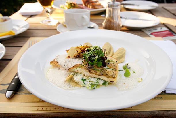 Walleye fillet with artichokes and molecular froth on restaurant table