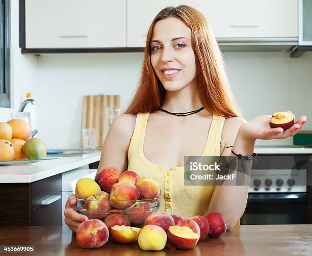 Foto de Mulher Segurando Pêssegos À Mesa Em Casa e mais fotos de stock de 20 Anos - 20 Anos, Adulto, Alimentação Saudável
