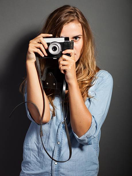 istock Photographer in jeans jacket taking pictures with old camera 453681577