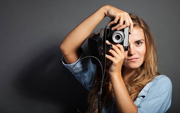 istock Photographer in jeans jacket taking pictures with old camera 453681599