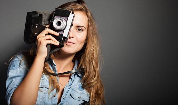 istock Smiling photographer woman with old camera 453681697