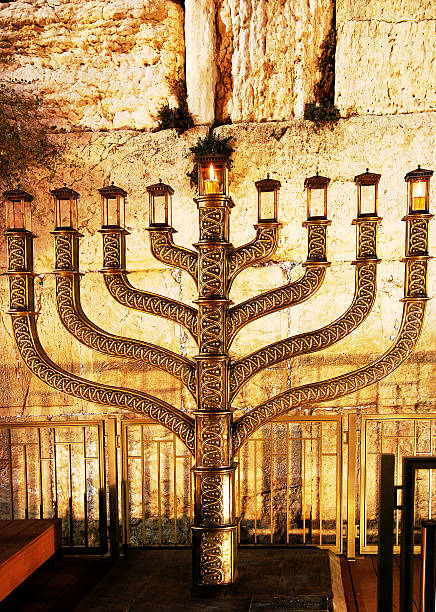 The Menorah of Hanukka in Jerusalem A Menorah is a candle stand with nine branches. Usually eight candles - one for each day of the Festival Hanukka - are of the same height, with a taller one in the middle, the shamash ("servant"), which is used to light the others. Each evening of Hanukkah, one more candle is lit, with a special blessing. rabbi photos stock pictures, royalty-free photos & images