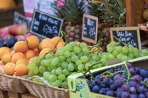 An early morning market in Saint Florent, Corsica selling fresh grapes and other fruit.