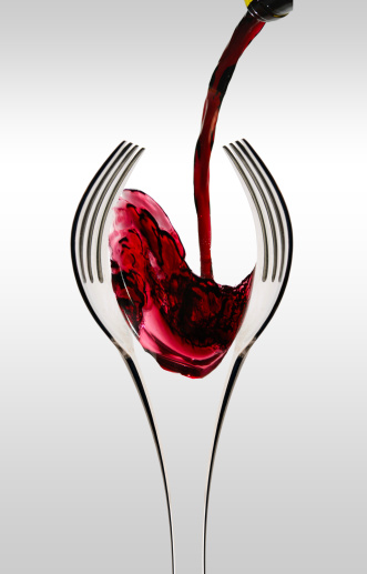 Wine being poured into two forks shaped like a wine glass