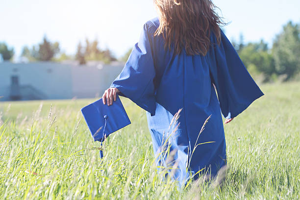 A young female graduate walking stock photo
