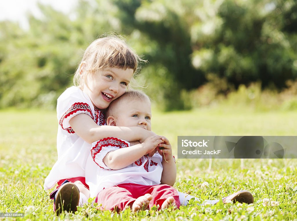 happy children in  folk clothes happy children in  folk clothes on grass meadow 2-3 Years Stock Photo