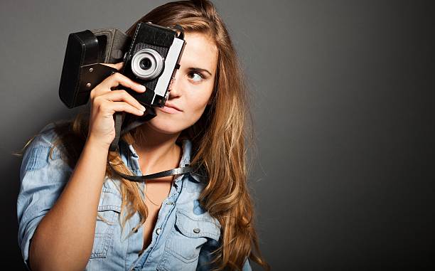 istock Silly photographer woman with old camera 453747381