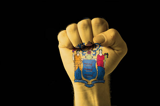 Fist painted in colors of us state new jersey flag Low key picture of a fist painted in colors of american state flag of new jersey jerseyan stock pictures, royalty-free photos & images