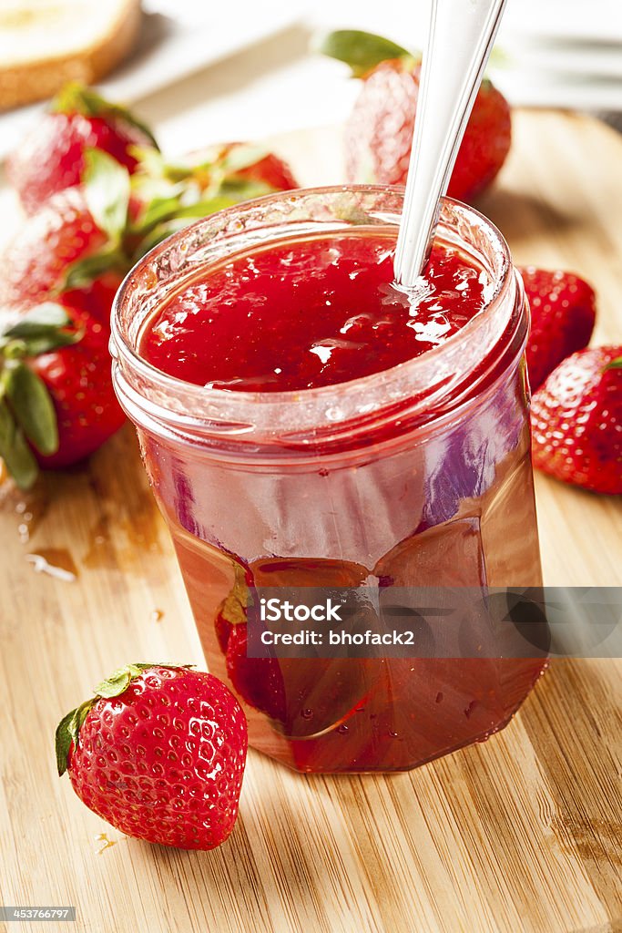 Homemade Organic Red Strawberry Jelly Homemade Organic Red Strawberry Jelly against a background Berry Stock Photo