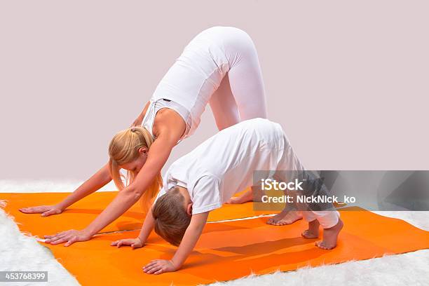 Bellissima Giovane Madre Con Il Figlio Pratiche Yoga - Fotografie stock e altre immagini di Adulto