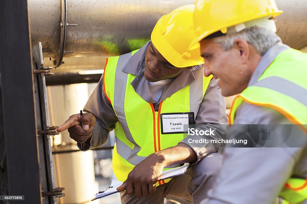 mechanical engineers working on fuel pipeline two mechanical engineers working on fuel pipeline in plant Active Seniors Stock Photo