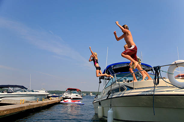 istock Children Jumping off Boat 453787329